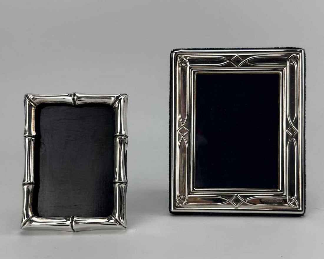 PAIR OF TIFFANY & CO. STERLING SILVER PICTURE FRAMES: Pair of small vintage sterling silver desktop photograph frames including one Chinoiserie bamboo motif frame and one geometric criss-cross border frame. Approximate Dimensions: larger 5" h x 4"