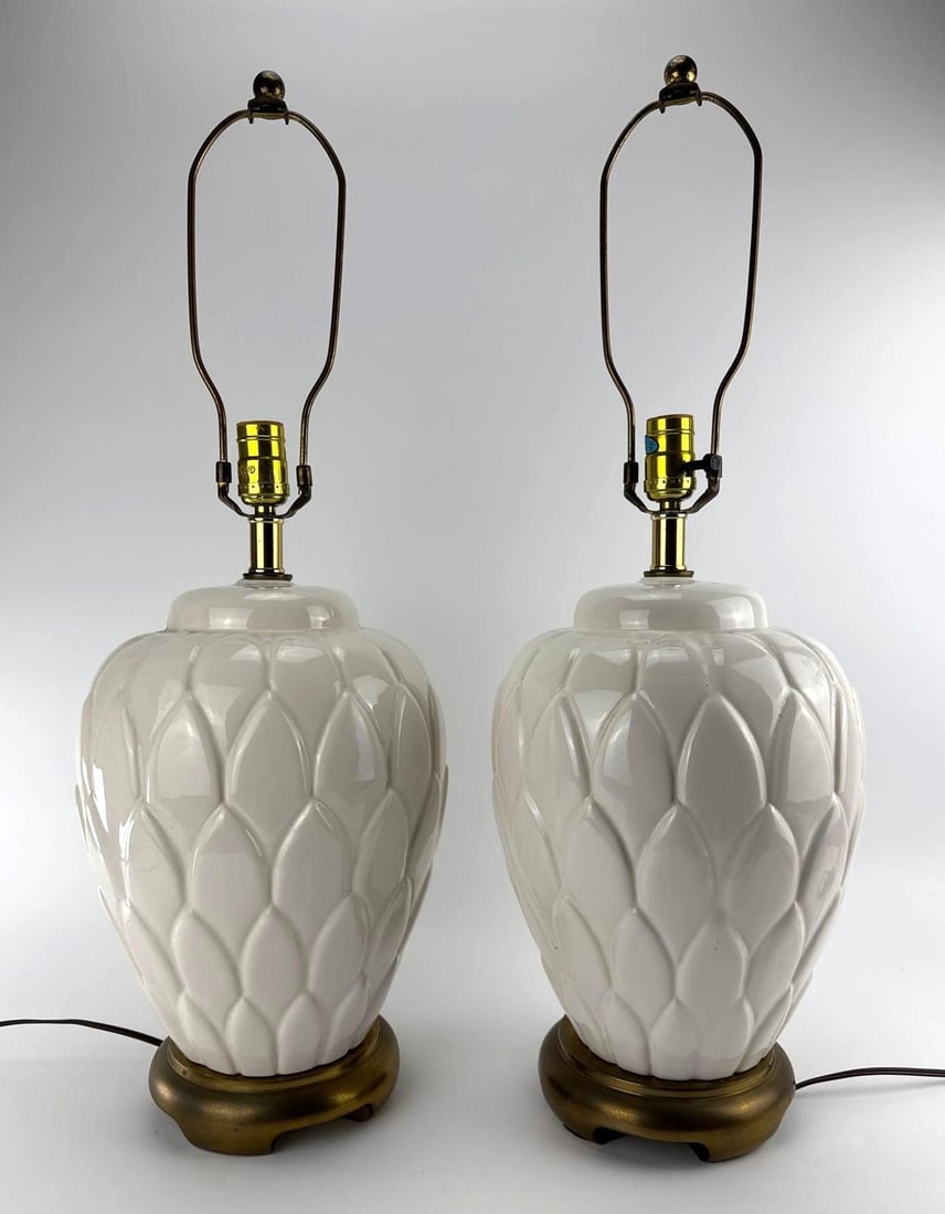 PAIR VINTAGE WHITE GLAZED CERAMIC ARTICHOKE FORM TABLE LAMPS: Pair of vintage urn-form ceramic table lamps styled with relief-molded white glazed artichoke leaf detailing, set on round antiqued brass-tone bases. Approximate Dimensions: 28” T x 9” Dia