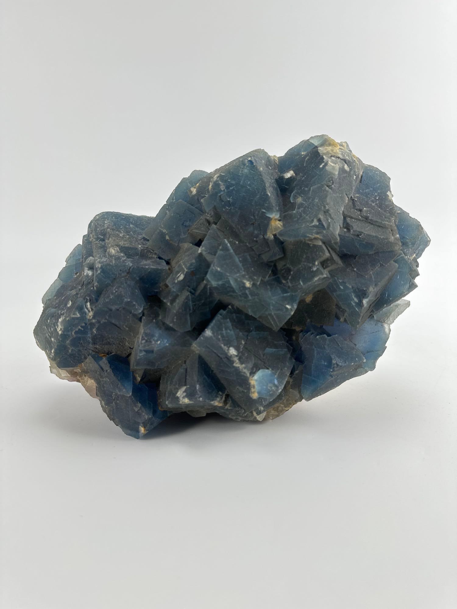 LARGE 11 INCH NATURAL BLUE CUBIC FLUORITE CRYSTAL CLUSTER SPECIMEN: Cabinet-size natural mineral specimen composed of dense, intergrown blue cubic fluorite crystal formations Approximate Dimensions: 11”x5”x7” Artist or Maker: Unknown