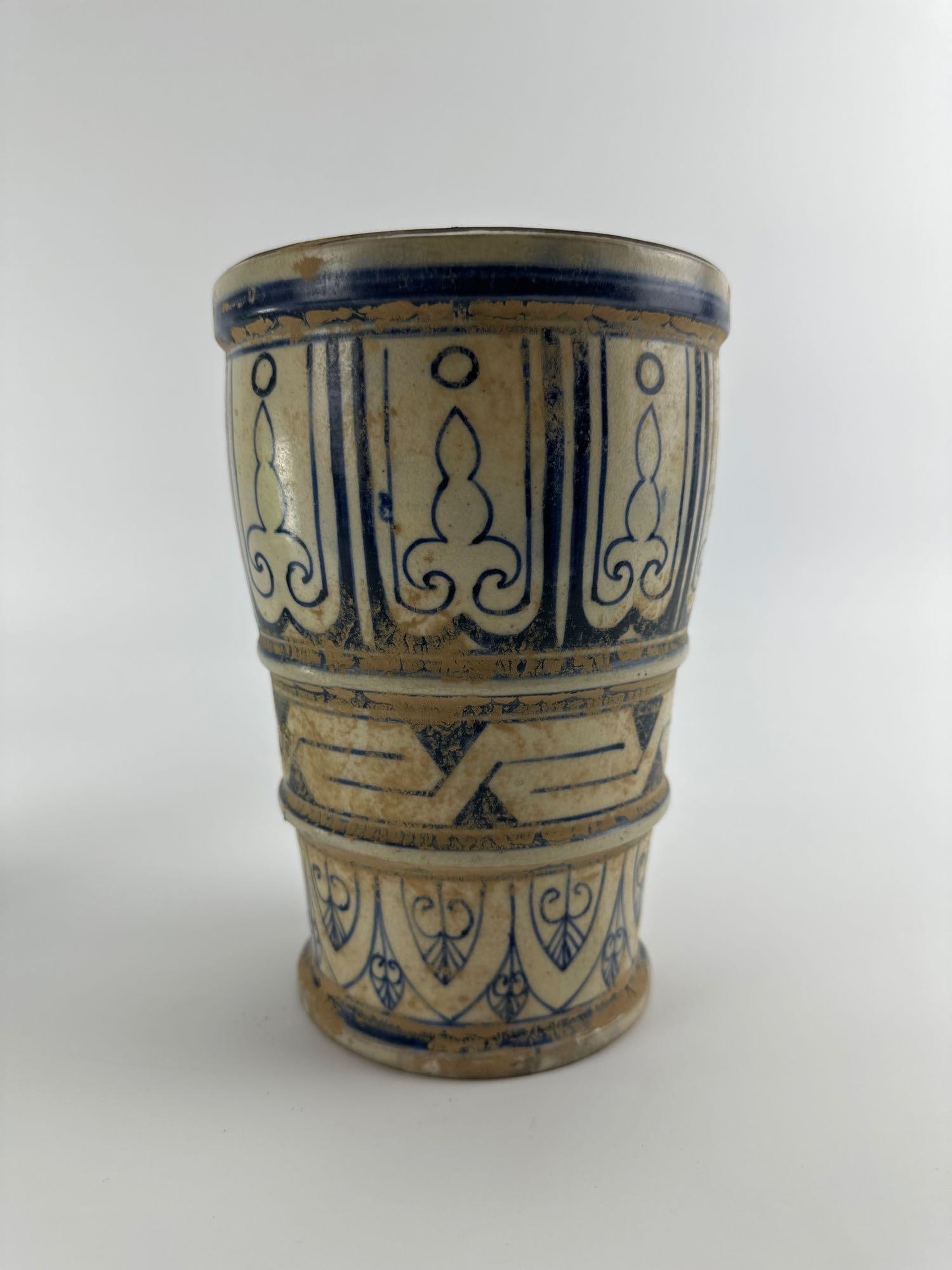 VINTAGE GREEK REVIVAL MAJOLICA STYLE BLUE AND WHITE TERRACOTTA VASE: Cylindrical tin-glazed terracotta vase decorated with hand-painted blue Greek key meander bands, floral palmettes, and scrolling leaf motifs on an aged cream ground Approximate Dimensions: 5.5”d