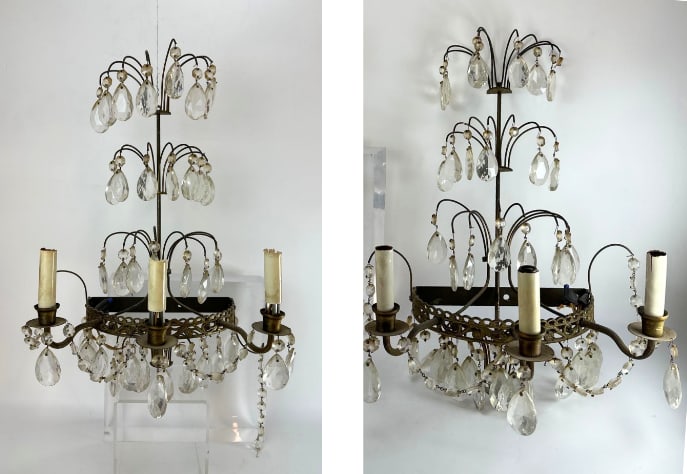 DISCOVERY LOT PAIR OF BRASS AND CRYSTAL WATERFALL WALL SCONCES: Pair of three-arm brass wall sconces with cascading faceted crystal drops arranged in three tiers, in a "waterfall" style. Approximate Dimensions: 9"W x 9"D x 21"H Artist or Maker: