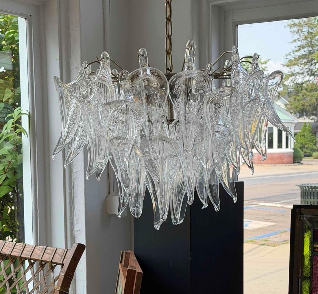 STUNNING MURANO / CAMER PULEGOSO GLASS CALLA LILY CHANDELIER: A mid-century Italian chandelier with a chrome-finish frame supporting numerous hand-blown clear glass leaf-form elements suspended from a chain mount. Approximate Dimensions: 25"w x 19"h Arti