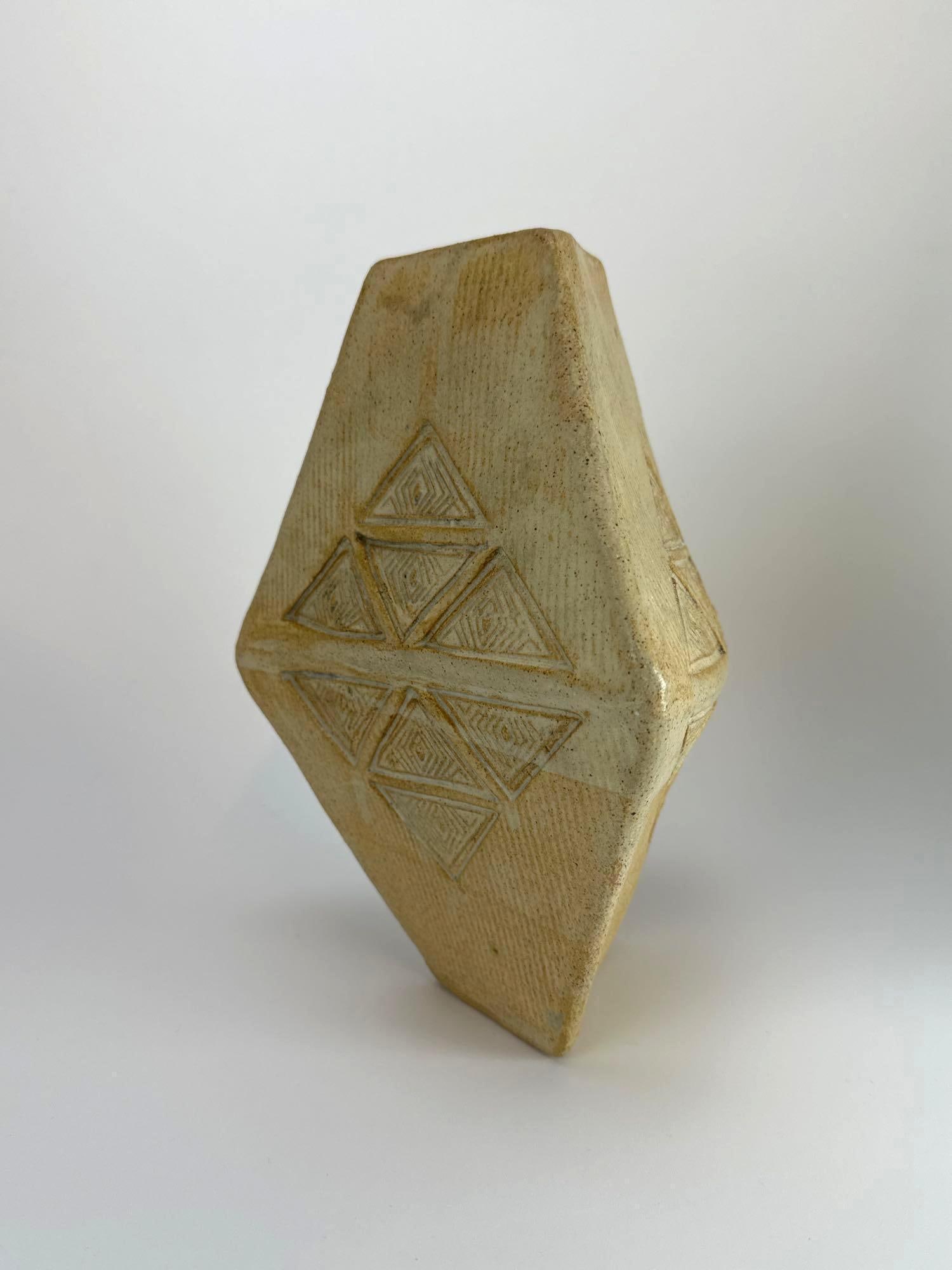 MODERN STUDIO CERAMIC VASE, FACETED FORM, INCISED DECORATION, MARKED PV: Modern studio pottery vase of angular faceted form with incised linear decoration in a matte tan glaze marked PV on bottom Approximate Dimensions: 9" H x 7" W x 7" D Artist or Maker: Unkno