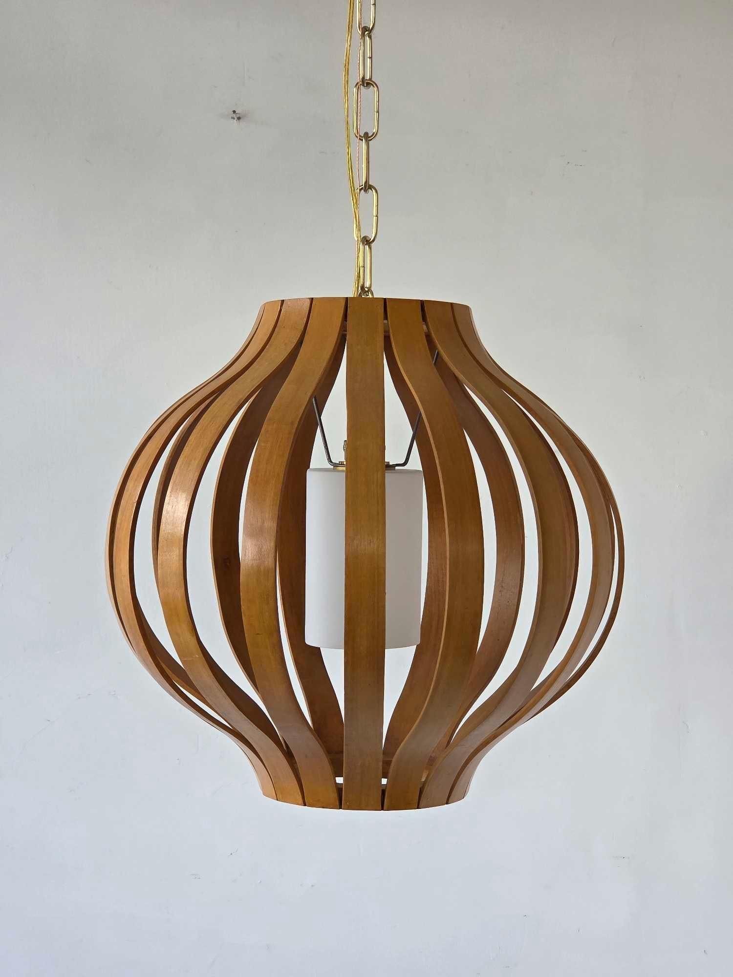 MID-CENTURY MODERN BENTWOOD SLAT GOURD-SHAPED PENDANT FIXTURE IN THE MANNER OF HANS-AGNE JAKOBSSON: Suspended ceiling light fixture composed of vertically undulating teak or walnut finished bentwood slats forming an open gourd-like cage around a central white cylindrical glass diffuser sleeve attach