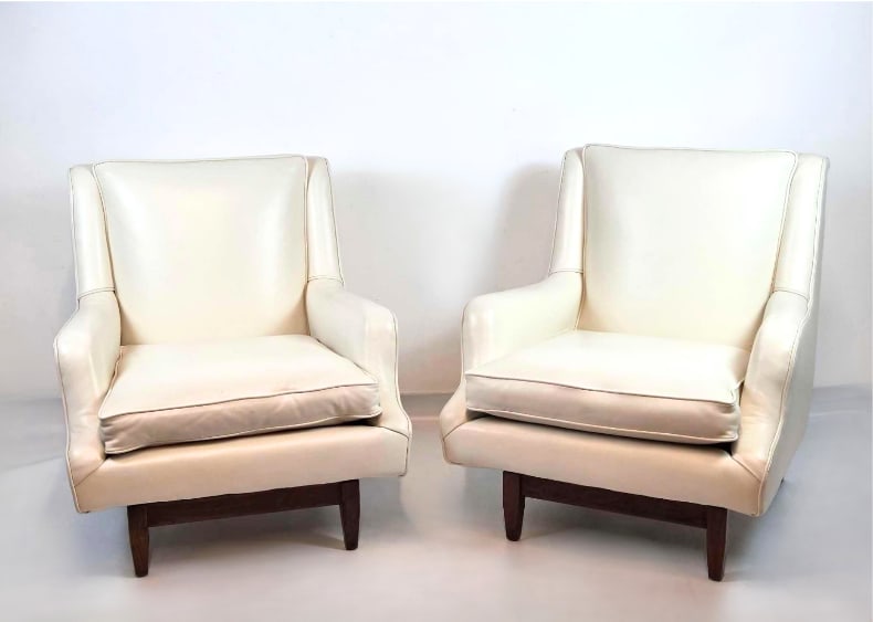 FINE PAIR MID CENTURY IVORY LEATHER UPHOLSTERED WING ARM CHAIRS: Fine pair of mid century modern wing form arm chairs in ivory leather upholstery on dark wood block feet Approximate Dimensions: 32" H x 28.5" W x 31" D each Artist or Maker: Unknown