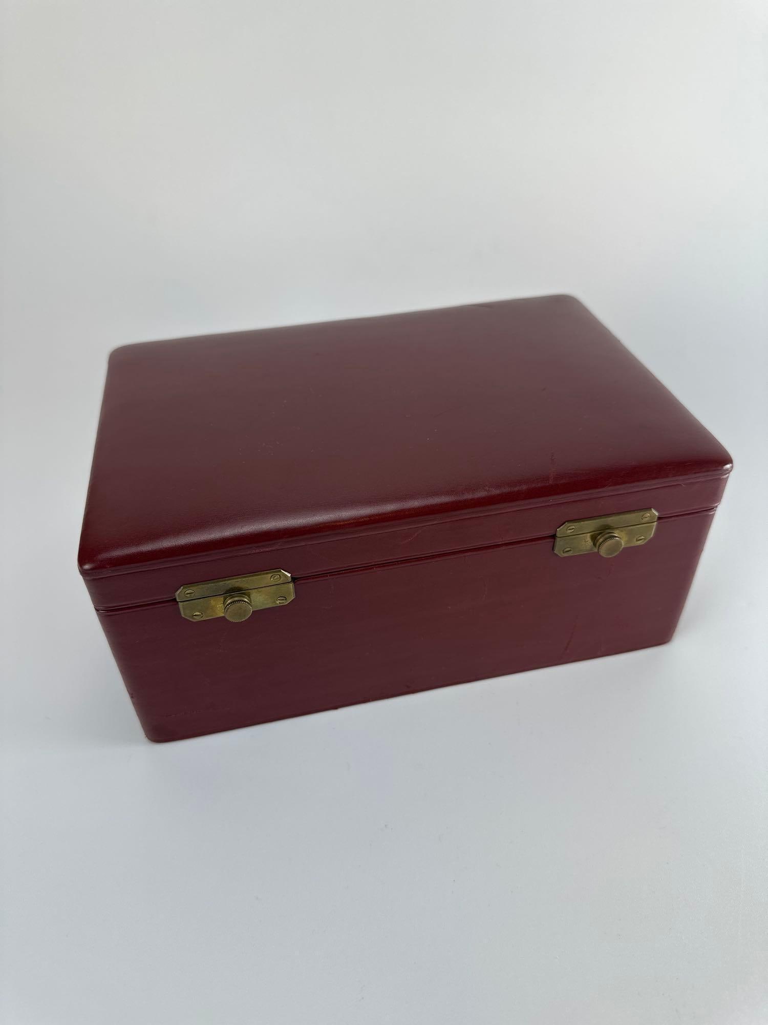 FRENCH GALALITH GAMING CHIP SET IN FITTED CASE KIRBY BEARD & CO. ATTR.: Cased gaming chip set with polychrome galalith chips in fitted trays, red case with brass clasps Approximate Dimensions: 4" H x 9" W x 6" D (case) Artist or Maker: Unknown Provenance: