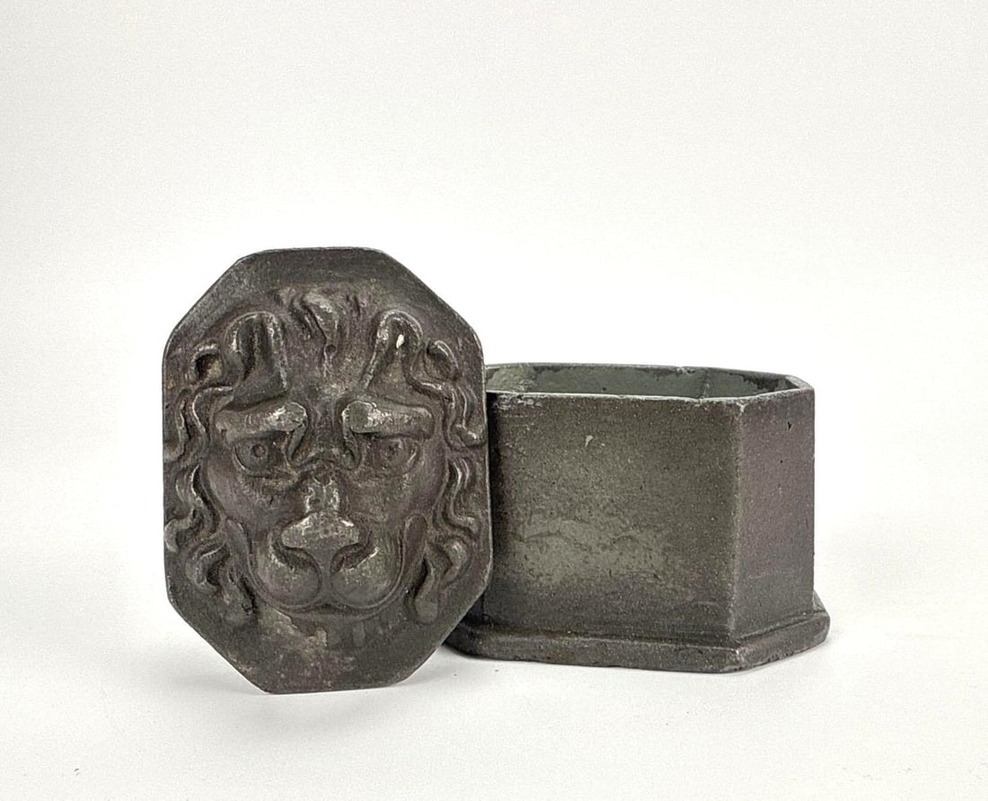 ANTIQUE LION MASK METAL LIDDED BOX/ TOBACCO KEEPER: Small heavy cast metal lidded box with a lion mask in relief on the lid, dark patina Approximate Dimensions: 3.5" H x 4" W x 3" D Artist or Maker: Unknown Provenance: From the estate of a 