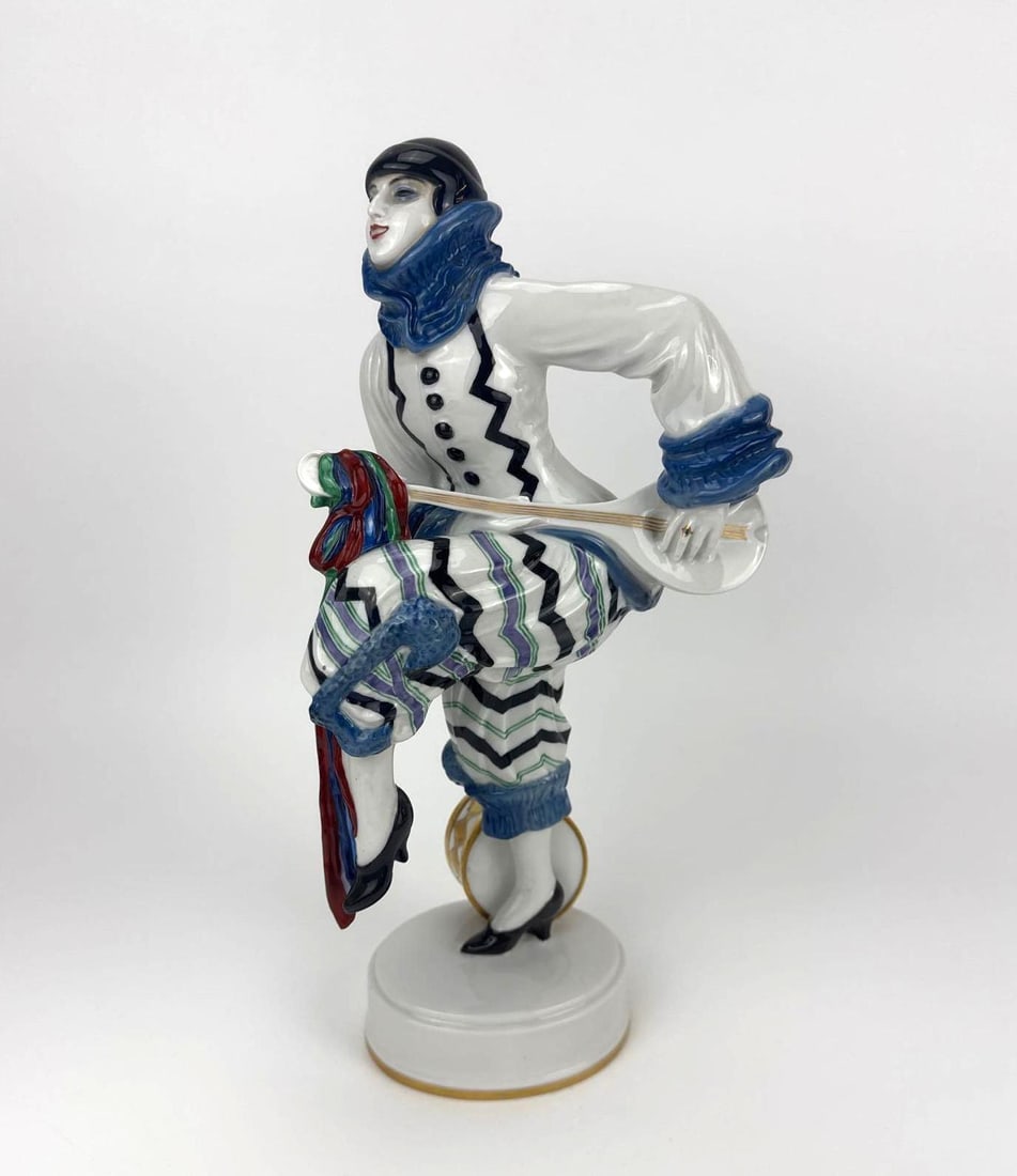 ROSENTHAL ART DECO PORCELAIN FIGURE "LUSTIGER MARSCH", GERMANY, 20TH CENTURY: Rosenthal porcelain figure "Lustiger Marsch," a costumed figure in blue-and-white striped dress on a gilt-rimmed base. Approximate Dimensions: 14.5" H X 5" W X 7" D Artist or Maker