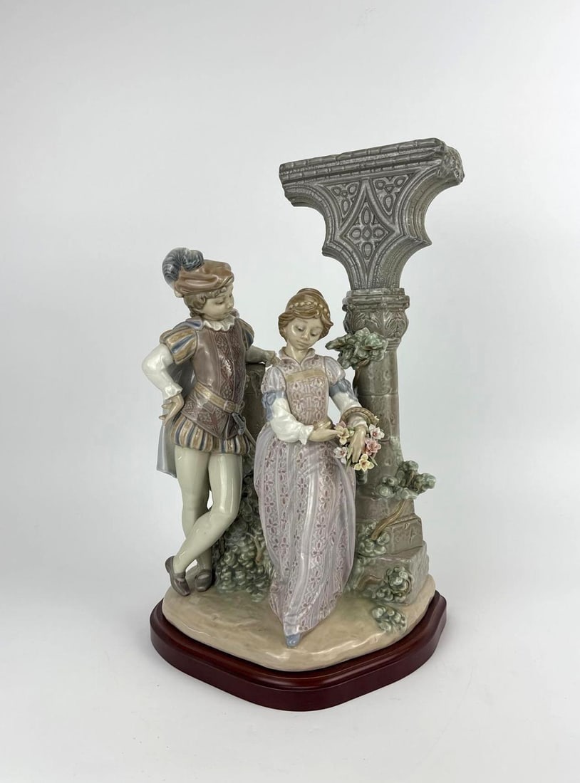 LLADRÓ "MEDIEVAL COURTSHIP", WITH ORIGINAL BOX: Lladró porcelain group "Medieval Courtship" a courting couple with flowers beside a classical column, on a wood base; (signed / dated,includes original box. Approximate Dimensions: 14.5" H X 9" W X 8