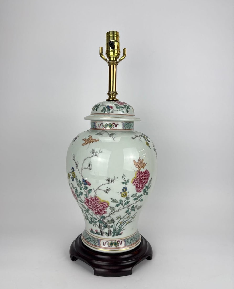 CHINESE FAMILLE ROSE GINGER JAR TABLE LAMP: Porcelain ginger jar table lamp with famille rose peony and butterfly decoration on a carved wood base. Approximate Dimensions: 22" H X 11" Dia. Artist or Maker: Unknown; Chinese-style famille