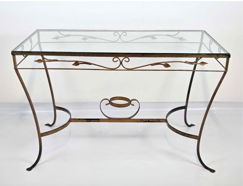 SALTERINI-STYLE GILT WROUGHT IRON GLASS-TOP TABLE: Gilt wrought iron glass-top table with scrolled apron and splayed scroll-foot legs. Approximate Dimensions: 29.5" H X 48" W X 28.25" D Artist or Maker: Unknown; in the manner of Salterini 