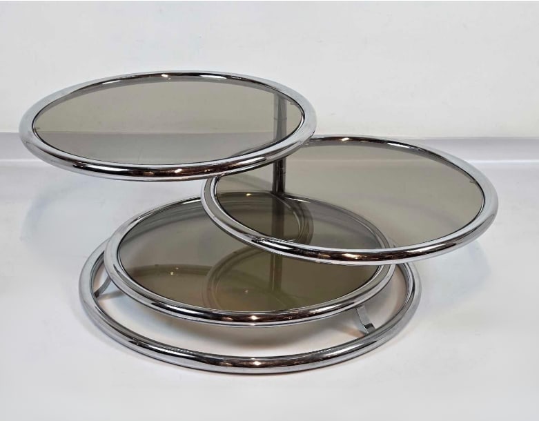 ITALIAN MID CENTURY CHROME AND GLASS CIRCULAR THREE TIER ADJUSTABLE COFFEE/COCKTAIL TABLE: *Italian mid-century modern space-age coffee table featuring three circular smoked glass tiers set in polished tubular chrome rings; the two upper tiers swivel and adjust independently for flexible co