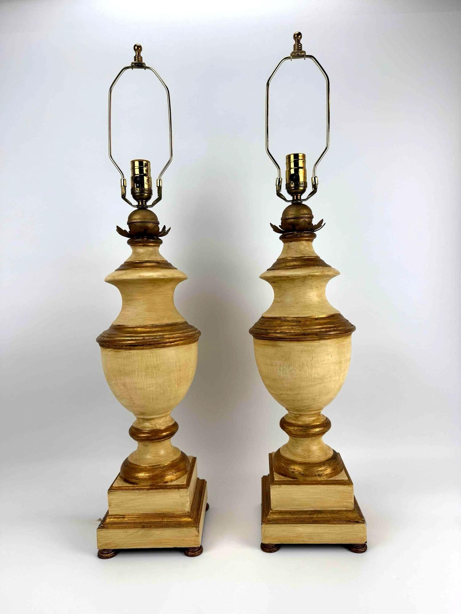 PAIR OF GILTWOOD URN-FORM TABLE LAMPS: Pair of carved giltwood urn-form table lamps on stepped square plinths. Approximate Dimensions: 24.5" H X 6.75" Dia.; 32" H to top of harp. Artist or Maker: Unknown Provenance: From a New 