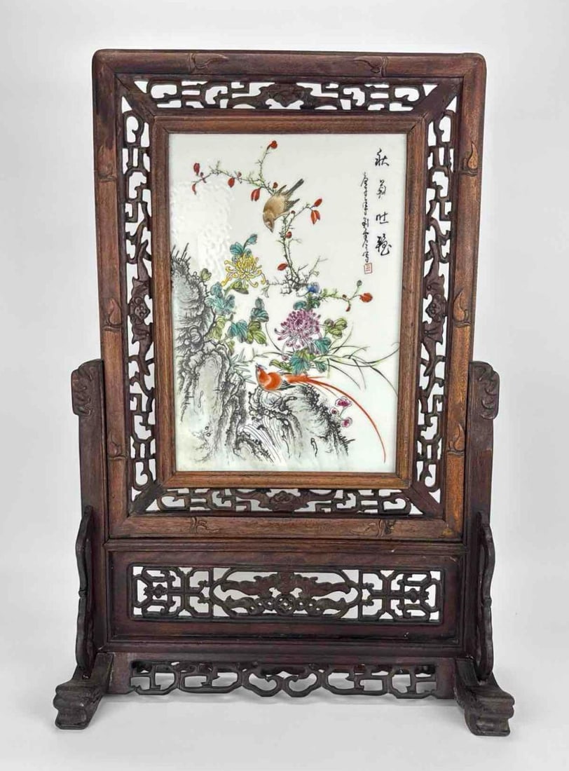 CHINESE FAMILLE ROSE PORCELAIN PLAQUE IN CARVED HARDWOOD TABLE SCREEN: *Vintage Chinese table screen featuring a hand-painted Famille Rose porcelain plaque with black calligraphy and seal mark, inset within a reticulated carved hardwood frame and matching stand. NOTE: se