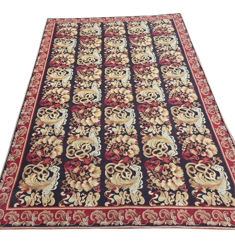 BOLD PATTERN VINTAGE NEEDLEPOINT RUG: *A needlepoint rug showcasing a bold, repeating baroque scroll pattern over a dark chocolate brown field framed by a rich red foliate border. Approximate Dimensions: 9' L x 6' -3" W Artist