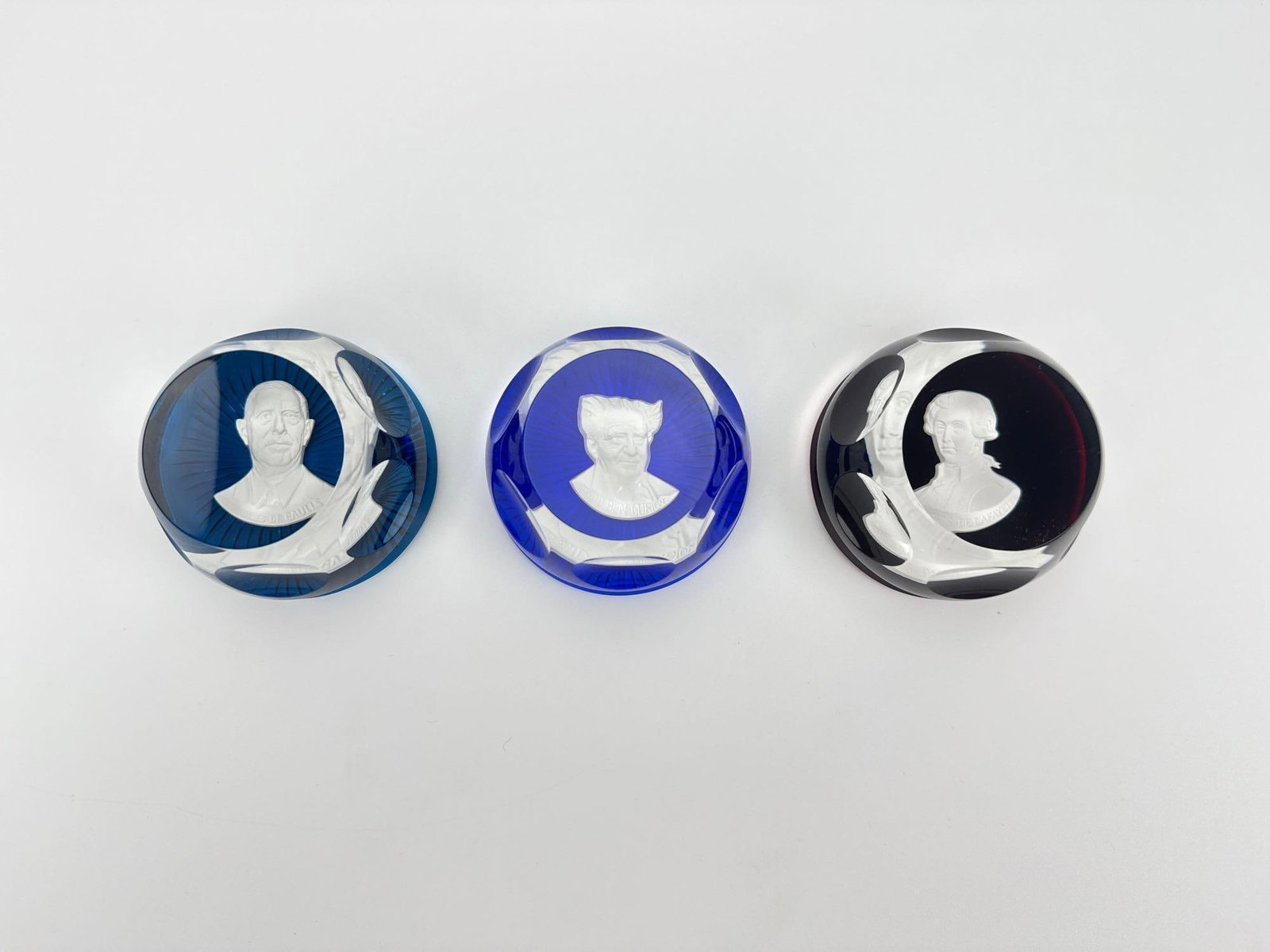 LOT OF 3 BACCARAT FOR FRANKLIN MINT CAMEO CRYSTAL PAPERWEIGHTS: *Set of three French Baccarat crystal sulphide paperweights commissioned for the Franklin Mint, featuring cobalt, royal blue, and ruby red overlay bases with thumbprint faceted edges, each encasing a 