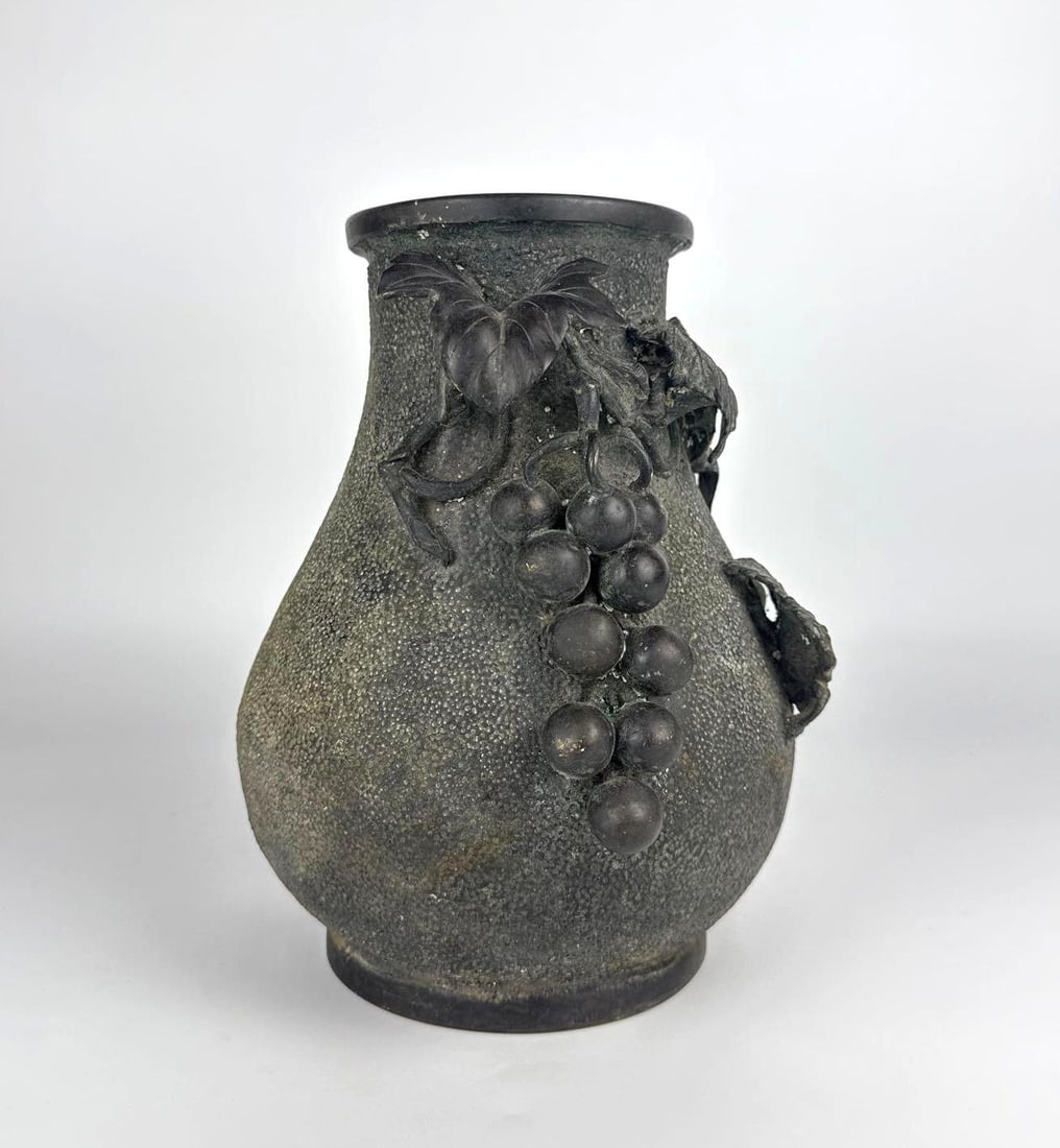 JAPANESE LATE MEIJI PERIOD BRONZE HIGH-RELIEF GRAPE VINE VASE: *Antique Japanese vase featuring a dark textured ground decorated with high-relief applied bronze grape clusters, leafy vines, and tendrils wrapping around the shoulder. Approximate Dimensions: 10&rdq