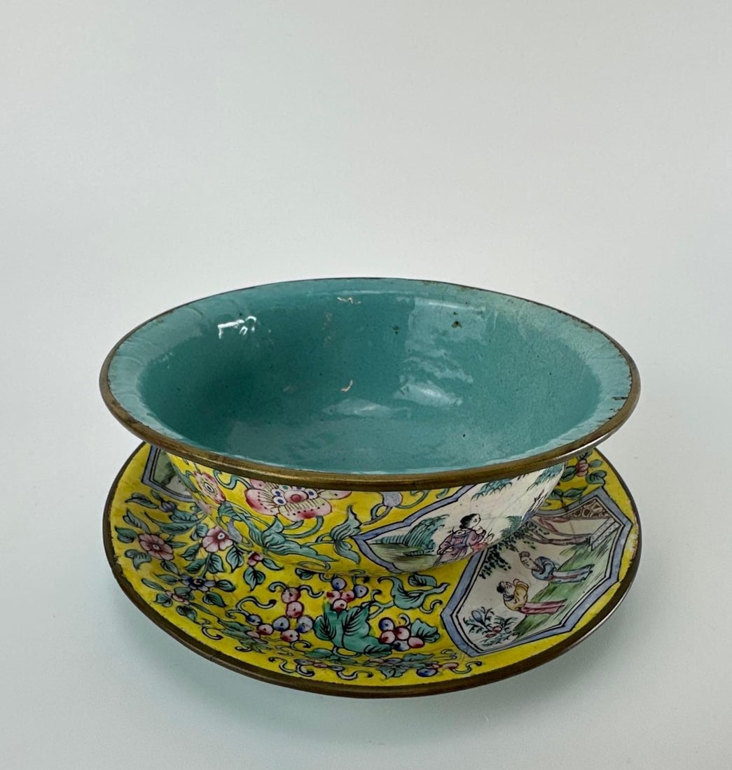 CHINESE CANTON ENAMEL YELLOW GROUND BOWL AND SAUCER: *Chinese Canton enamel bowl and saucer, painted on copper with a yellow ground, figural garden vignettes, and floral scrollwork, turquoise enamel interior. Approximate Dimensions: 3”H x 6”