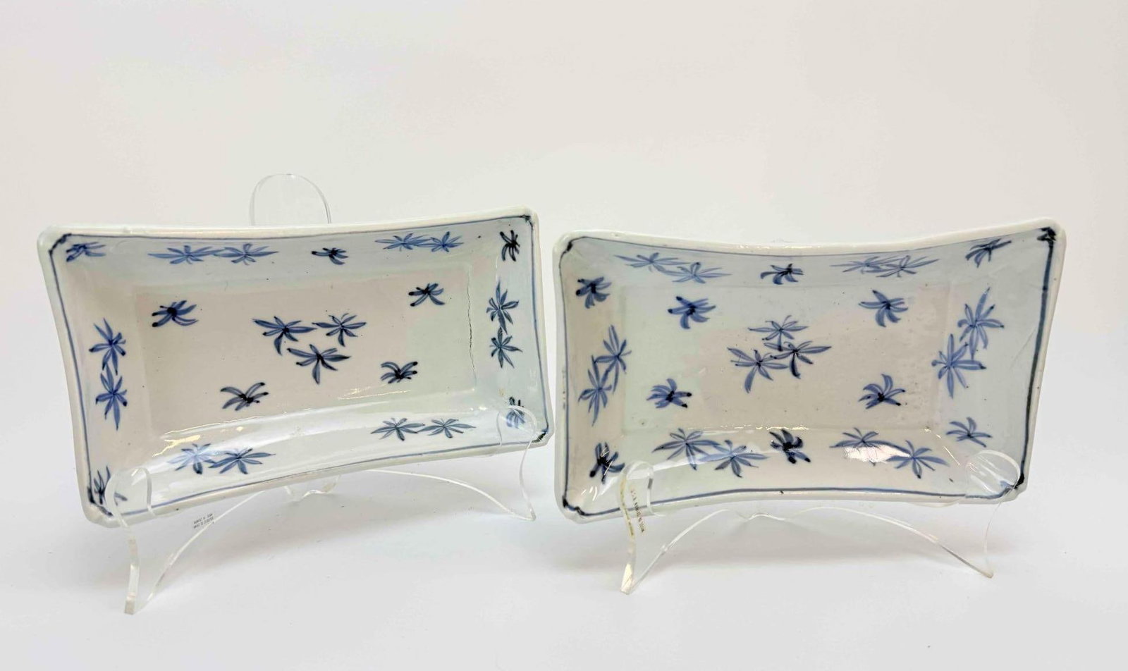 PAIR OF CHINESE BLUE AND WHITE RECTANGULAR PORCELAIN DISHES: Pair of small Chinese blue and white rectangular porcelain dishes with scattered bamboo and floral sprigs Approximate Dimensions: each 7.25" W x 4" D x 1.5" H Artist or Maker: Unknown Prov