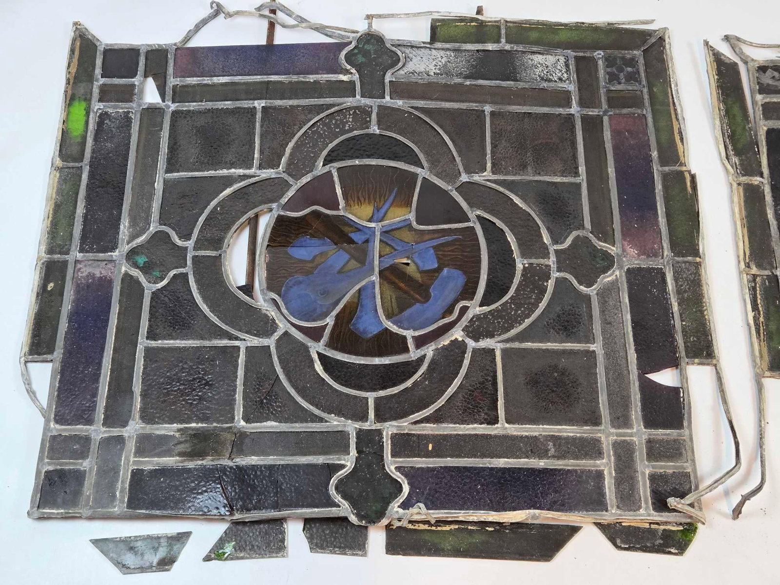 TWO ANTIQUE LEADED STAINED GLASS CHURCH WINDOW REMNANTS FRAGMENTS: Two antique leaded stained glass church window remnant panels Approximate Dimensions: largest 32" x 34" Artist or Maker: Unknown Provenance: From a New York Collector Notes: Although care is t