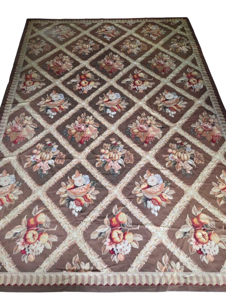 FINE ROOM SIZE AUBUSSON STYLE FLATWEAVE RUG: Fine room-size Aubusson-style flatweave wool rug, the chocolate-brown field divided by an ivory trellis into diamond compartments filled with floral and fruit bouquets in autumnal tones Approximate Di