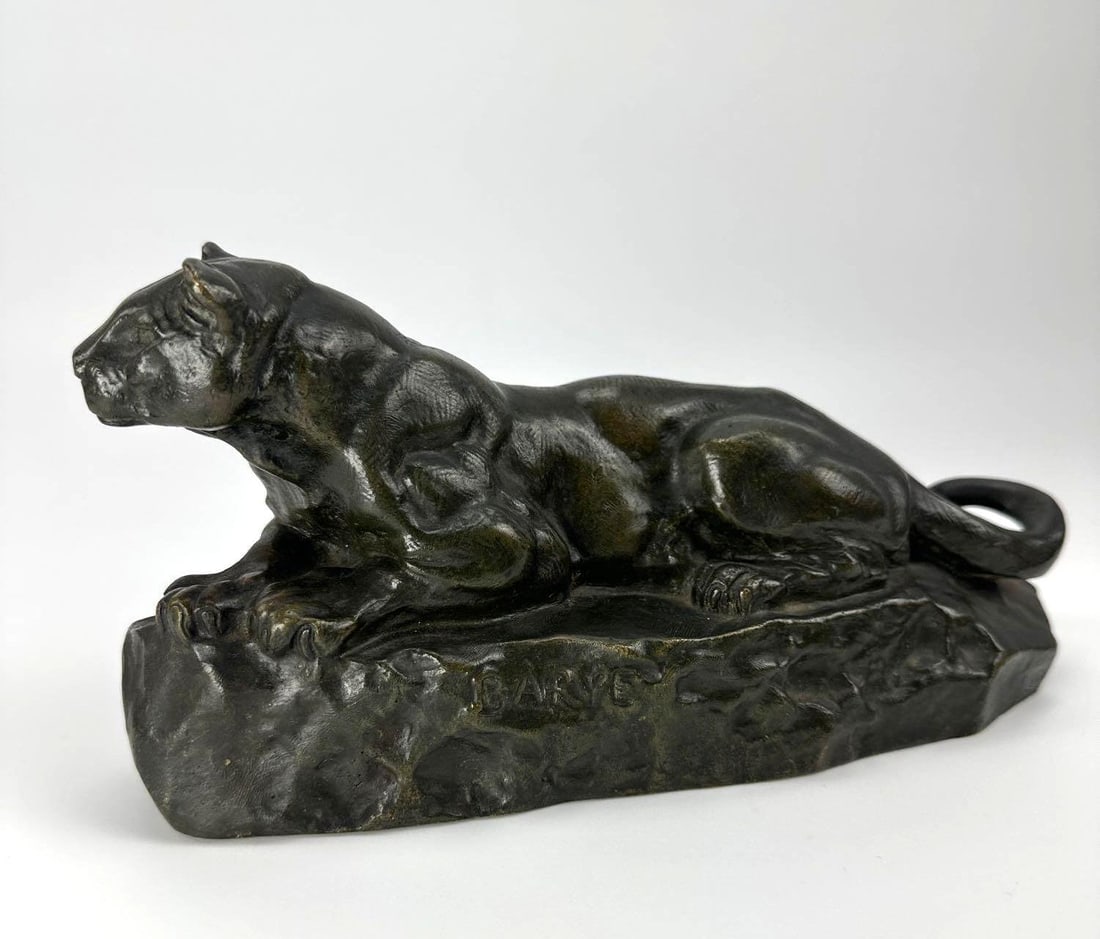 AFTER ANTOINE-LOUIS BARYE BRONZE PANTHER OF TUNISIA, CAST SIGNED: Patinated bronze recumbent panther on a naturalistic rocky base, cast signed. Approximate Dimensions: 5" H x 10" L x 4" W Artist or Maker: After Antoine-Louis Barye (French, 1795-1875) Pro