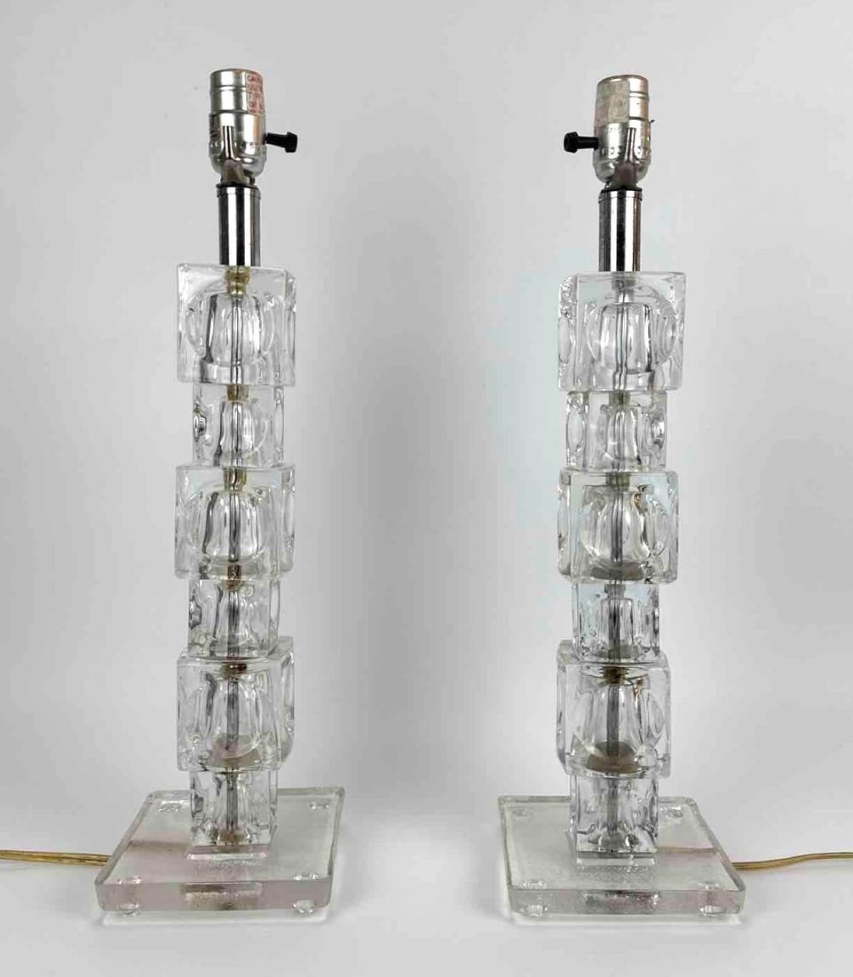 PAIR OF STACKED GLASS CUBE TABLE LAMPS, MID CENTURY MODERN ICE GLASS, WITH SHADES: Pair of table lamps, columns of stacked clear moulded ice-textured glass cubes rising from square glass plinth bases, chrome fittings, supplied with two non-matching off-white shades Approximate Dimen