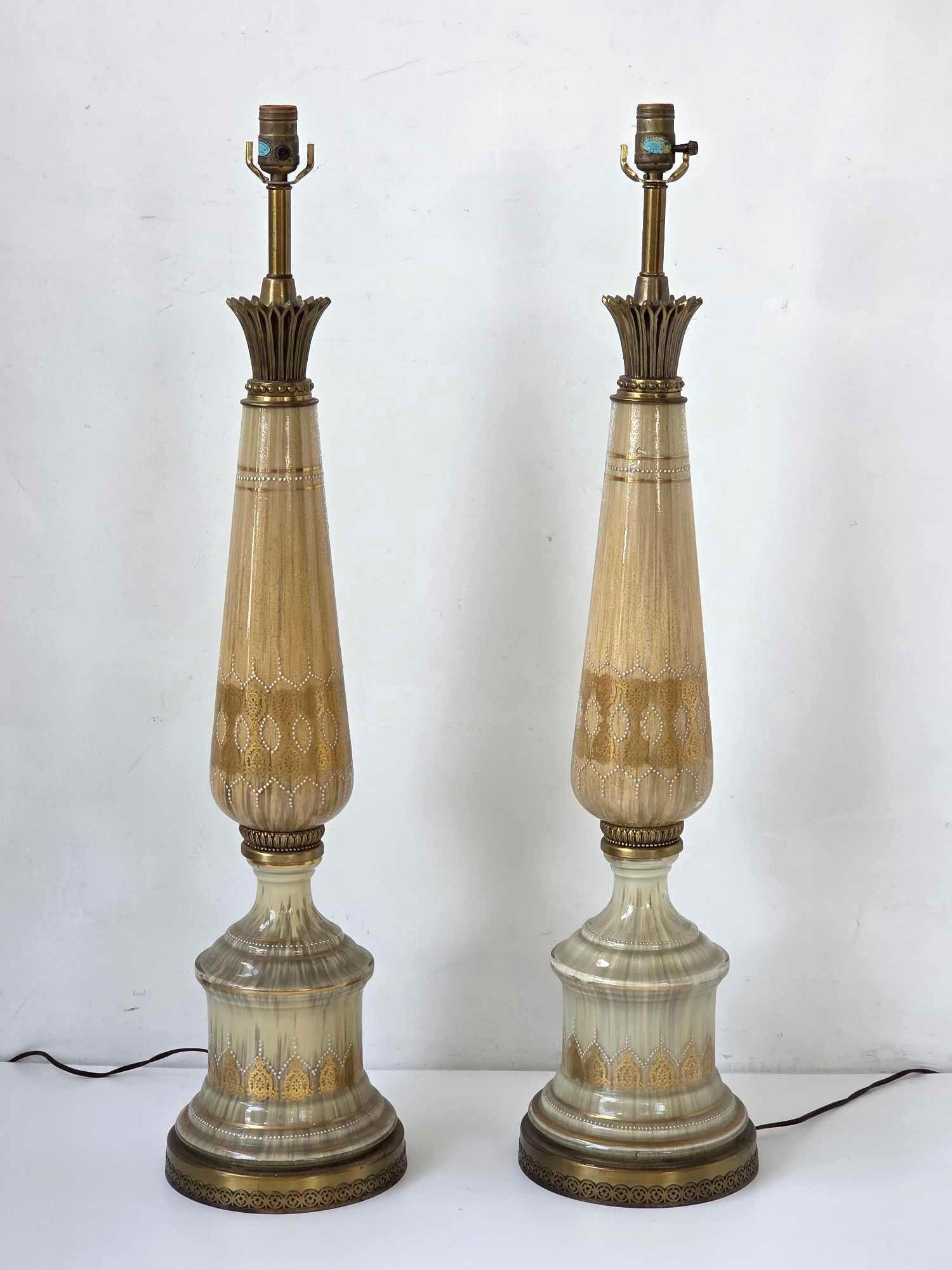 PAIR HOLLYWOOD REGENCY REVERSE PAINTED TALL TABLE LAMPS: Pair of tall Hollywood Regency table lamps in cream and amber striated reverse painted finish with gilt banding and spire form Approximate Dimensions: 37.25" H x 8.5" Dia. each Artist or Maker