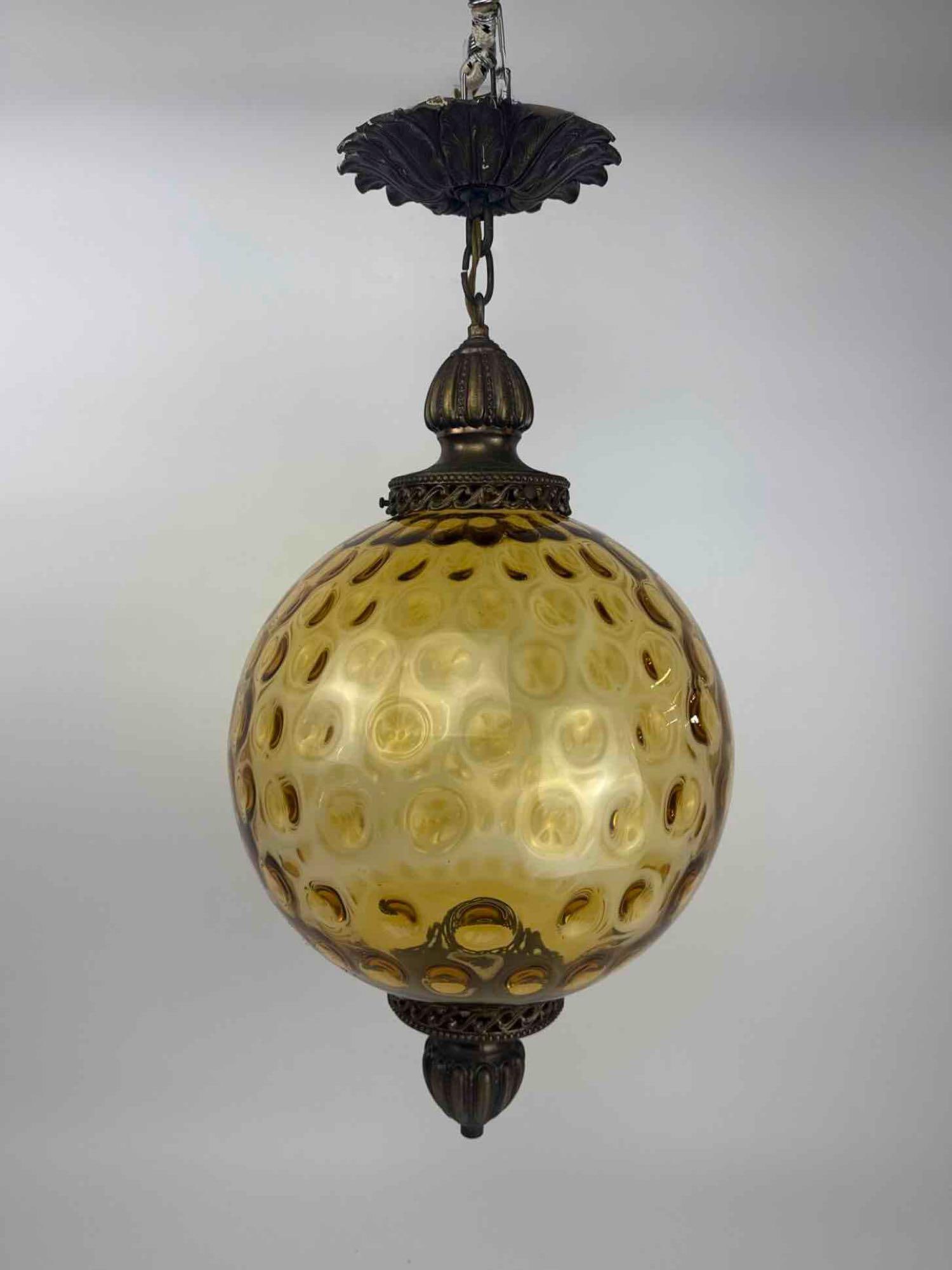 VINTAGE AMBER THUMBPRINT GLASS GLOBE PENDANT LAMP, HOLLYWOOD REGENCY SWAG: Hanging pendant light, spherical amber glass shade moulded with a dimpled thumbprint optic pattern. Approximate Dimensions: 23" H x 12" Dia. Artist or Maker: Unknown Provenance: From a New Yor