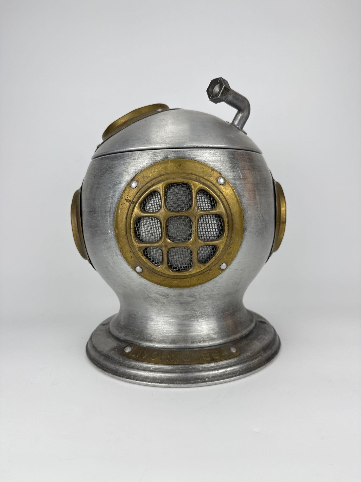 SEYMOUR MANN ITALIAN DIVER HELMET ICE BUCKET, U.S.S GILBEYS, 1970 (2 OF 2): Novelty ice bucket cast as a deep sea diving helmet. Approximate Dimensions: 12" H x 10 1/2" W x 10" D Artist or Maker: Seymour Mann Imports, made in Italy, copyright 1970. Marked on the u