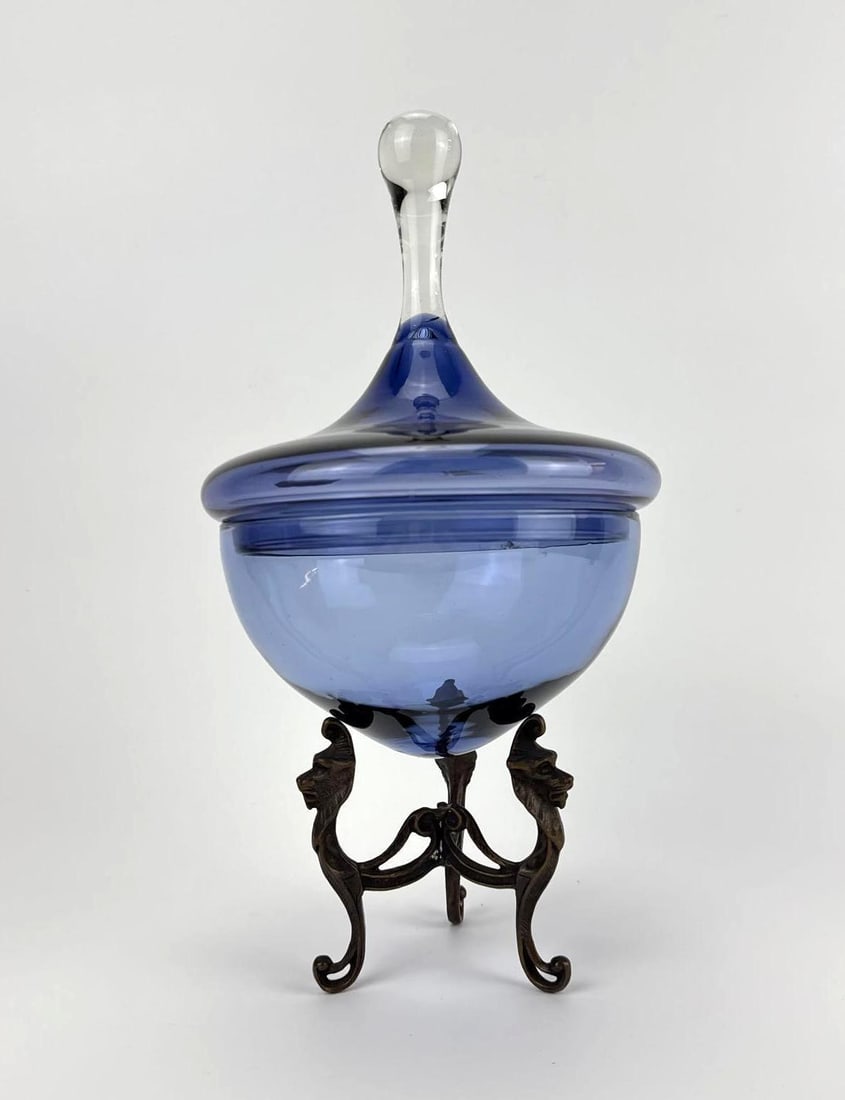 ITALIAN BLUE BLOWN GLASS COVERED BOWL ON BRONZE GRIFFIN TRIPOD STAND: an Italian blown glass covered bowl raised on a cast bronze tripod stand - original labels. Approximate Dimensions: 13.5” H x 7.5” Dia. overall, as assembled Artist or Maker: Unsigned; gla