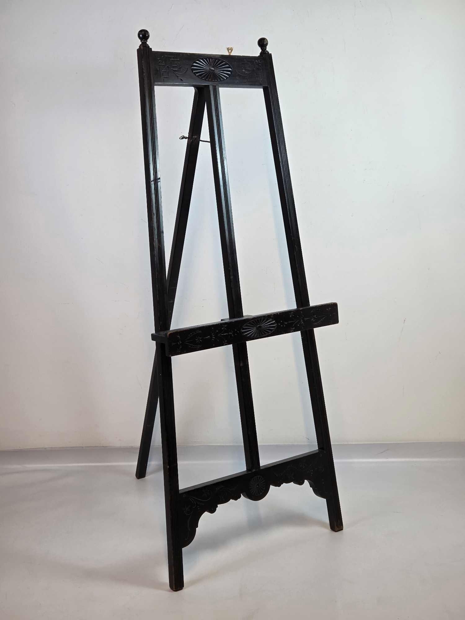 AESTHETIC MOVEMENT EBONIZED AND INCISED GILT ARTIST EASEL, ANGLO-JAPANESE TASTE: An Aesthetic Movement ebonized wood artist’s or display easel Approximate Dimensions: 69.5” H x 27” W x 36” D (as set up) Artist or Maker: Unsigned Provenance: From a New York Coll