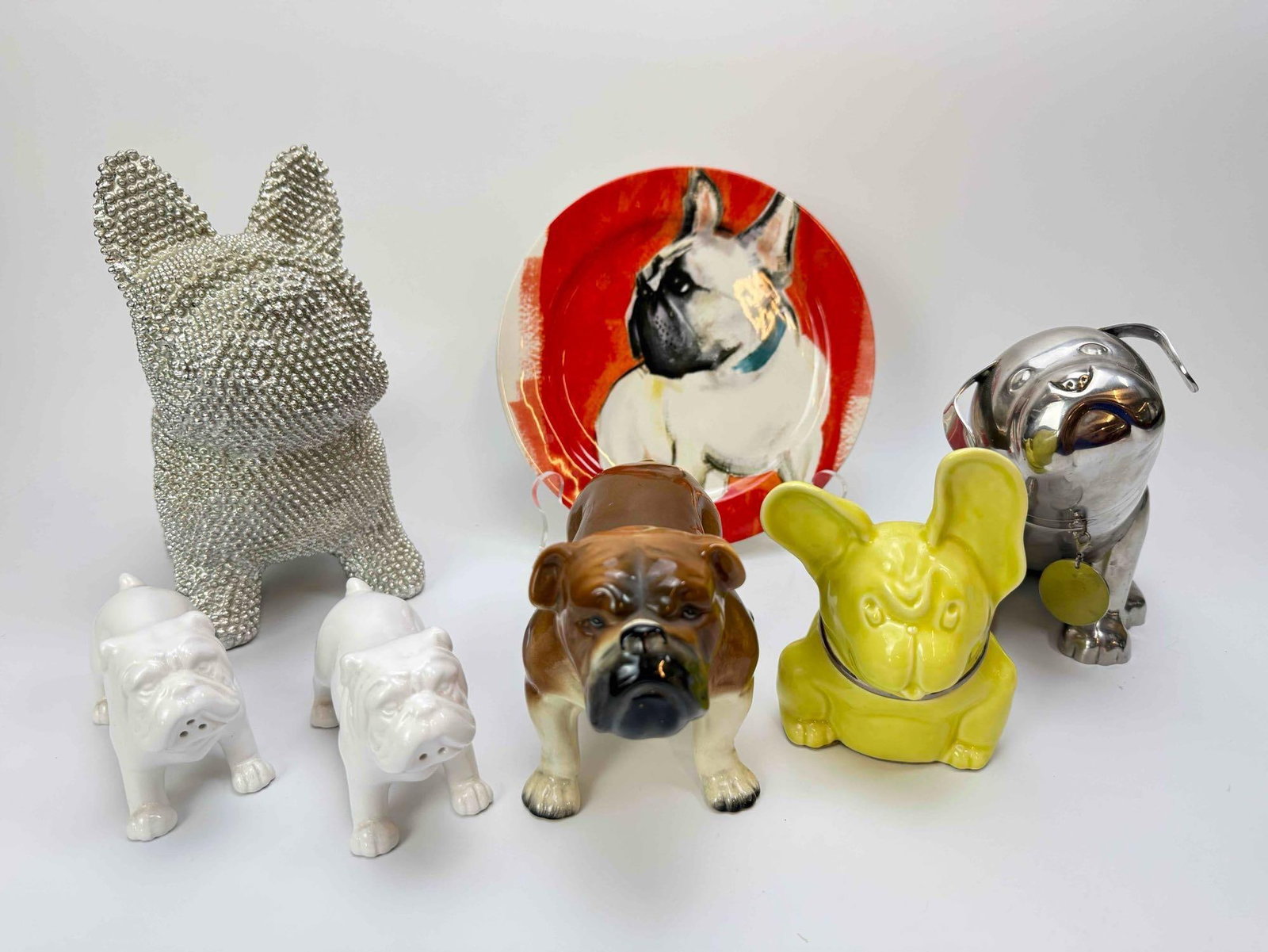 BULLDOG THEMED COLLECTION LOT: 8.75” H X 7.5” W Whimsical grouping devoted to the bulldog, including a framed line drawing, figures, and a decorative plate Artist or Maker: Various Provenance: A New York Gallerist and C
