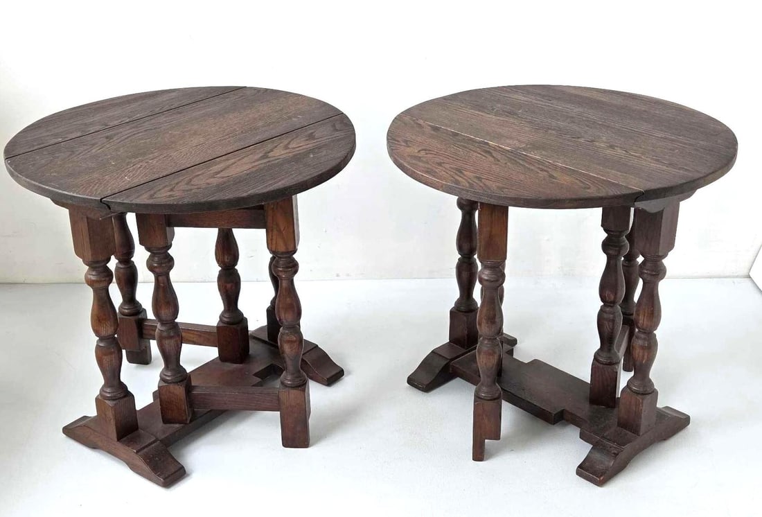 PAIR OF ENGLISH OAK DROP LEAF GATE LEG TABLES: A pair of small English oak gate leg tables, each with a drop leaf top opening to a circle, on baluster turned legs and shaped trestle feet Approximate Dimensions: 22.25" H x 23.75" Dia. open;