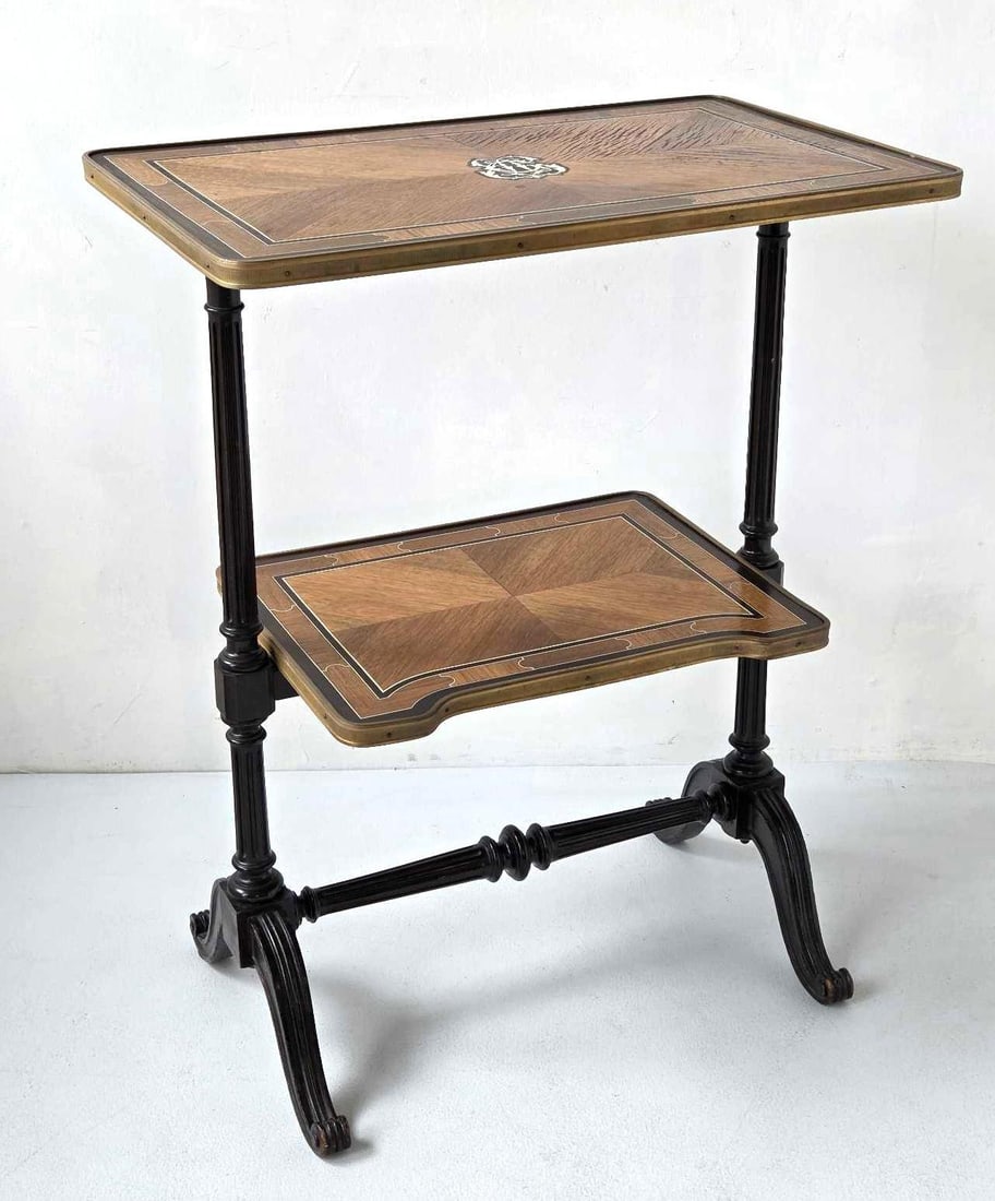 FINE SORMANI TWO TIER INLAID FOLDING TABLE: A fine two tier folding occasional table, each galleried tier with radiating marquetry inlay and a central foliate cartouche within gilt metal banding, on an ebonized turned and reeded folding frame w