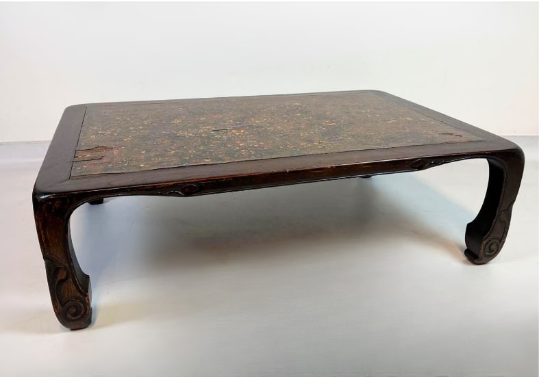 CHINESE CARVED HARDWOOD LOW COFFEE TABLE: Chinese carved hardwood low table with speckled lacquered top and carved apron Approximate Dimensions: 42"L x 20"W x 14"H Artist or Maker: Unknown Provenance: From a New York Collector Not