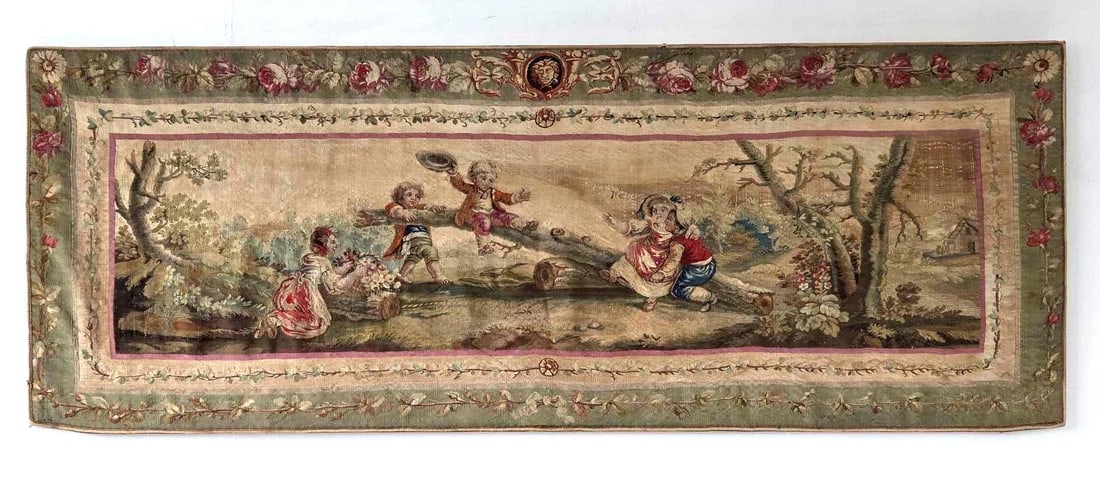 ANTIQUE HANDMADE TAPESTRY: A long horizontal tapestry panel woven with a romantic pastoral scene of courting figures in a wooded landscape, within a scrolling foliate and floral border Approximate Dimensions: 24" H x 74"