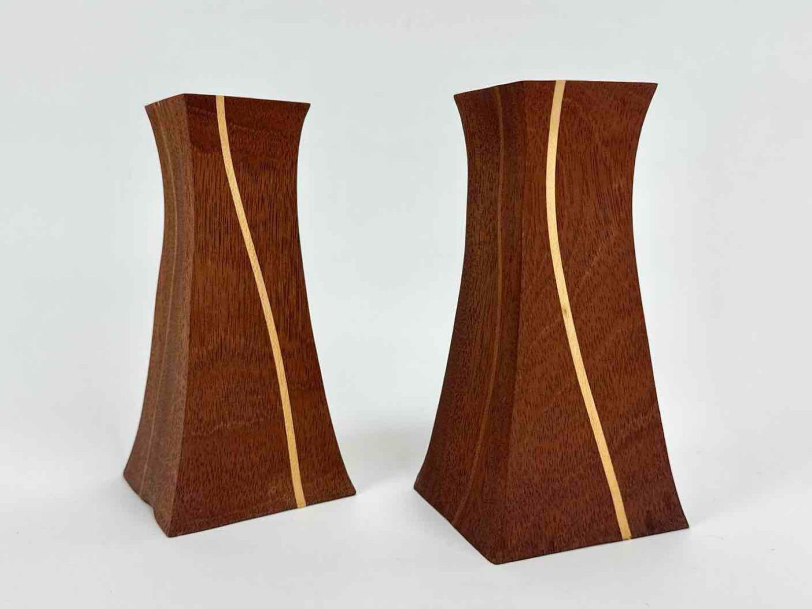 PAIR OF MID CENTURY MIXED WOOD INLAID CANDLESTICKS: A pair of mid century candlesticks of flared, waisted square form in a warm hardwood, each with a contrasting pale wood inlaid stripe running the height of the body Approximate Dimensions: 5.75" H