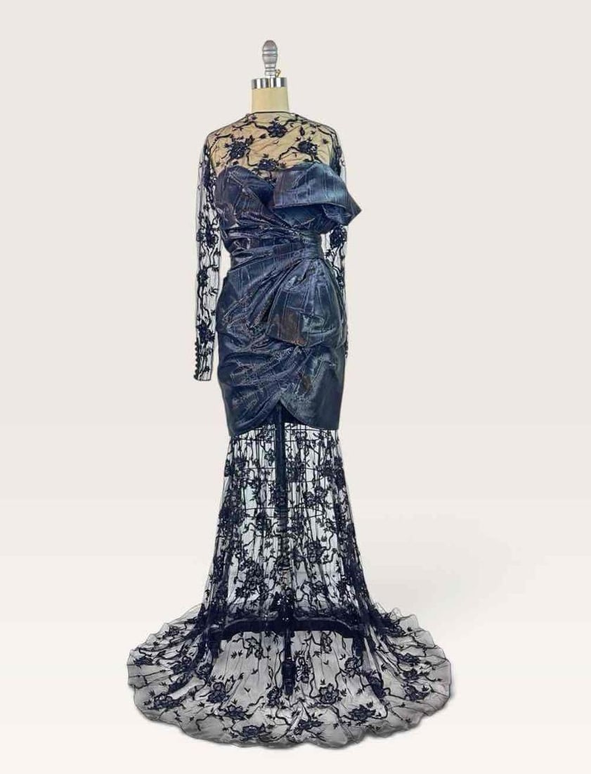 MOSCHINO COUTURE! BLACK LACE LONG SLEEVE GOWN, FW 2023 | ARCHIVAL SAMPLE: Full length black embroidered lace long sleeve gown with an iridescent taffeta sweetheart neckline mini dress overlay, draped and knotted taffeta at the waist and hip, lace mermaid skirt with sweeping