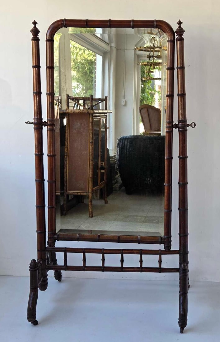FRENCH ANTIQUE NAPOLEON III FAUX BAMBOO CHEVAL MIRROR: Cheval dressing mirror, turned faux bamboo frame with arched crest, urn finials, spindle gallery stretcher, splayed feet, and swivelling rectangular mirror plate Approximate Dimensions: 65.5" H x 