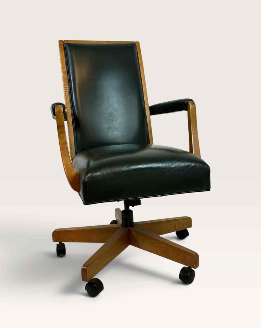 ETHAN ALLEN GREEN LEATHER AND WOOD SWIVEL DESK CHAIR: Mid century desk chair with dark green leather upholstered back and seat within a sculpted wood frame with shaped arms, raised on a wood swivel base with casters Approximate Dimensions: 24 x 24 x 41&#