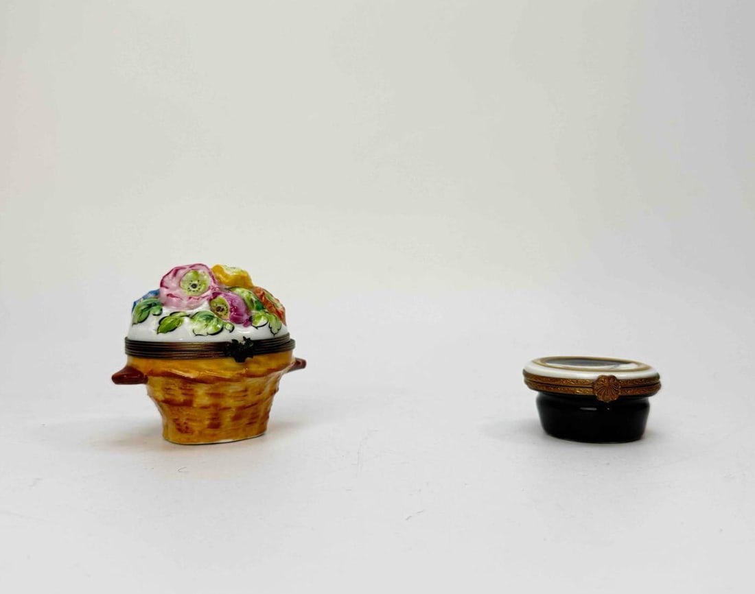 PAIR OF TRINKET BOXES INCLUDING APPLIED PORCELAIN FLORAL BASKET: Two small lidded trinket boxes, one a basket form with applied polychrome porcelain flowers, the other a low circular box in a dark banded finish Approximate Dimensions: Larger 2.75" H x 3" W 