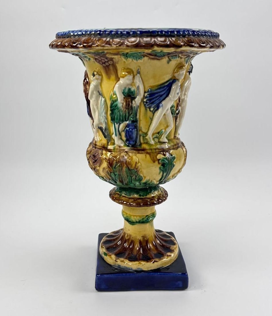 ITALIAN MAJOLICA CAMPANA URN WITH ISTORIATO FIGURAL DECORATION: Campana form majolica urn painted in the istoriato manner with classical figures in a landscape, with a moulded blue and white rim, socle foot and square cobalt plinth Approximate Dimensions: 13" 