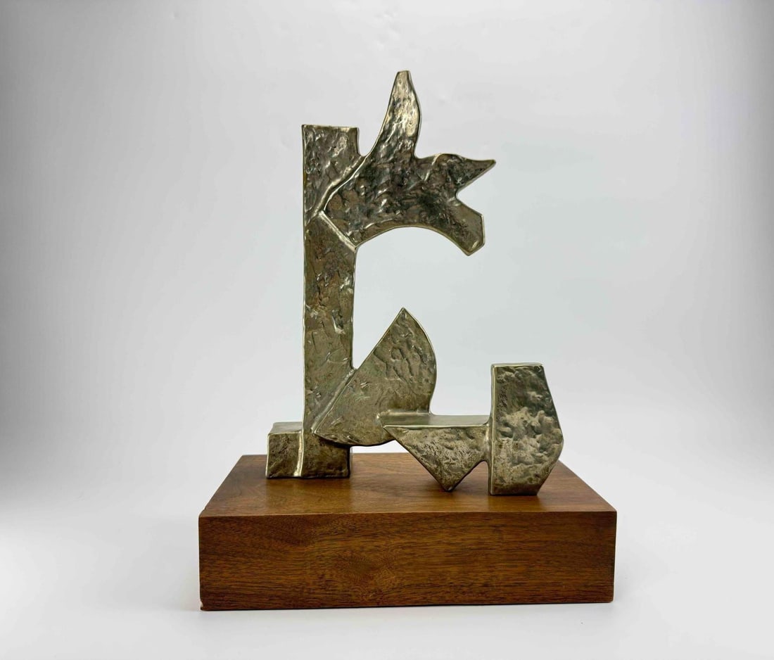 ODED HALAHMY ABSTRACT MODERNIST PATINATED METAL SCULPTURE ON WOOD BASE: Abstract sculpture of interlocking angular planes with a heavily textured surface and mottled green patina, mounted on a rectangular wood base. Dated 1976. Approximate Dimensions: 17" H x 13" 