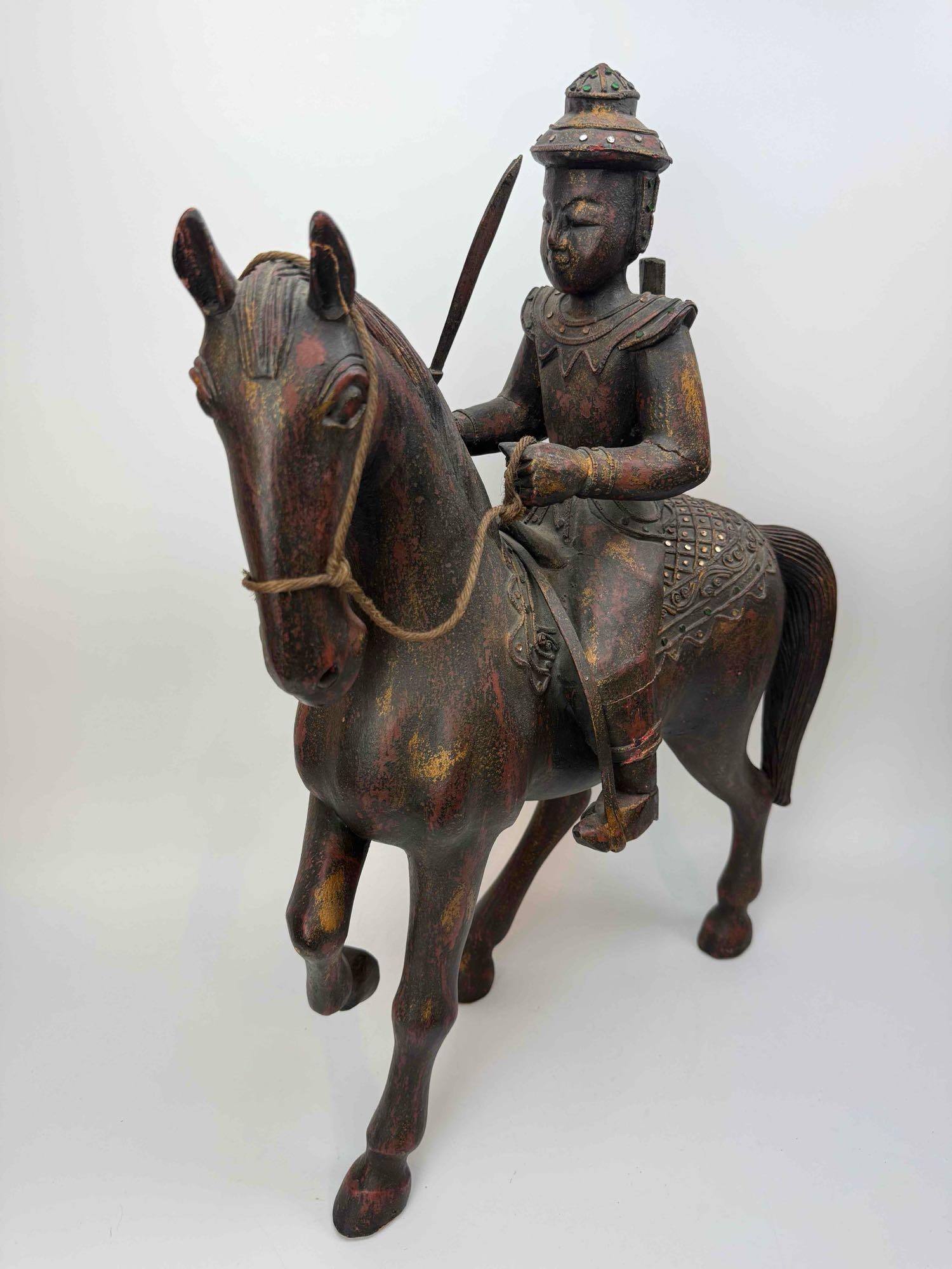 OVERSIZED TWO FOOT TALL CARVED WOOD POLYCHROME EQUESTRIAN FIGURE OF A MOUNTED WARRIOR: Hand carved wood group of a mounted figure in helmet and robes astride a standing horse with bridle and saddle cloth, in a dark stained finish Approximate Dimensions: 26" Tall Artist or Maker: