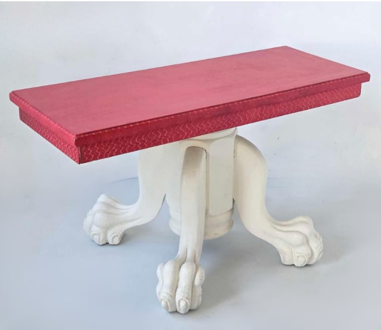 JOHN DICKINSON STYLE OCCASIONAL TABLE ON CARVED PAW FOOT BASE: Occasional table with a rectangular top covered in red fabric over a sculptural white painted pedestal base. Approximate Dimensions: 16.75" H x 30" W x 18" D Artist or Maker: Unknown Provenance: From