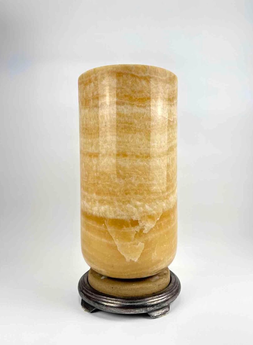 MASSIVE MID CENTURY MODERN CYLINDRICAL HONEY ONYX URN TABLE LAMP 22": An impressive, honey onyx cylindrical column table lamp on a fitted round base. Approximate Dimensions: 22” H x 10” Dia. Artist or Maker: Unknown Provenance: A New York Collector Notes: Although c