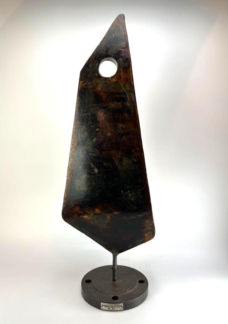 MICHAEL FUCHS ABSTRACT SCULPTURE DATED '87: Abstract sculpture of tapering blade form pierced by a circular void, with a mottled dark patinated surface, raised on a slender rod over a circular base Approximate Dimensions: 10" x 5" x 30" Artist 