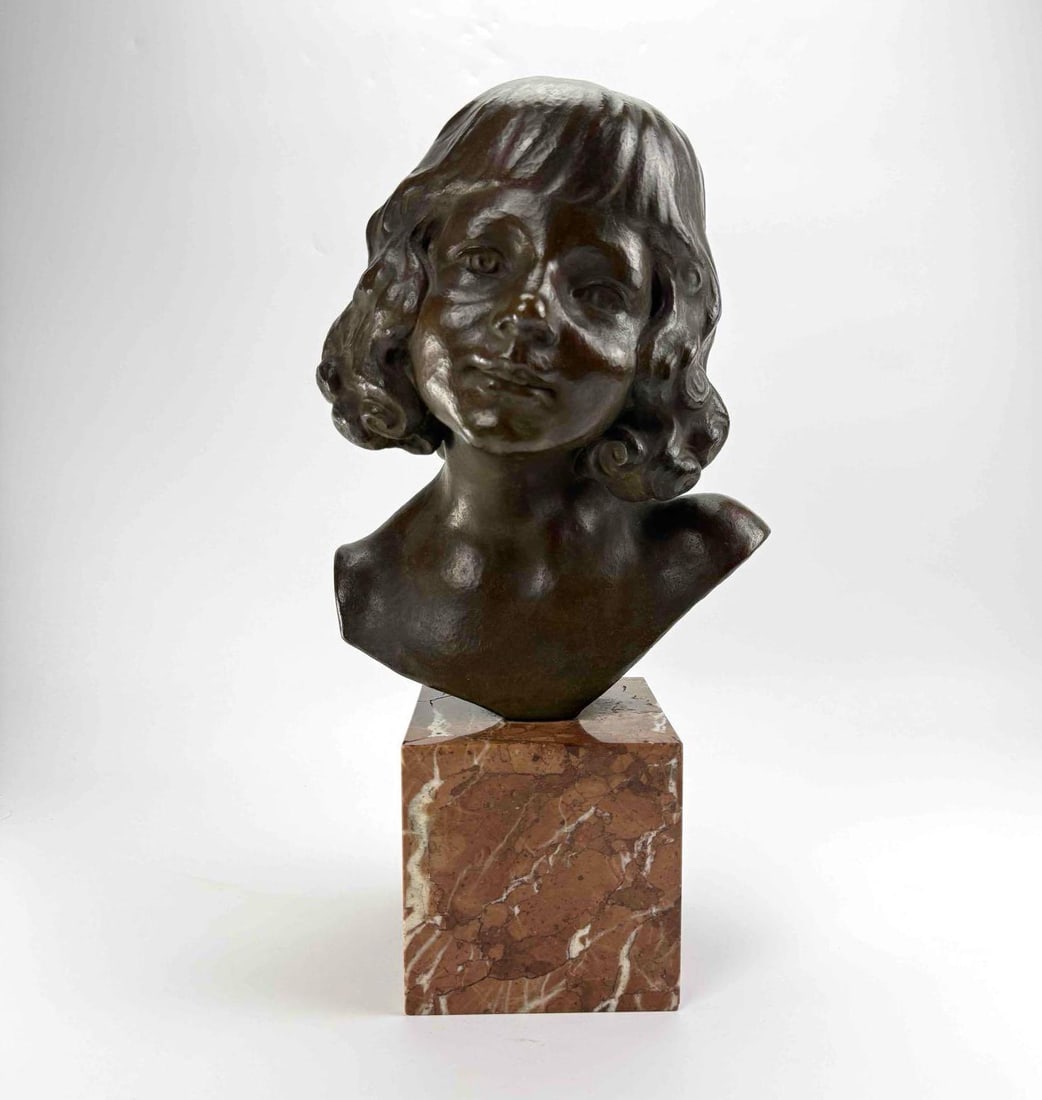 WERNER FENN SIGNED BRONZE BUST OF A YOUNG WOMAN ON ROUGE MARBLE PLINTH: Patinated bronze bust of a young woman with long waved hair and bare shoulders, raised on a square rouge marble plinth; signed "W. FENN" to the side/underside for the German sculptor Werner Fe
