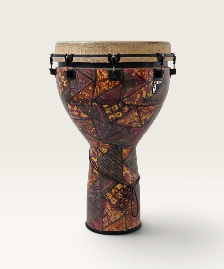REMO MONDO DJEMBE DRUM: A djembe hand drum with patterned fabric-covered Acousticon shell, metal tuning lugs, and rope carrying handle. Approximate Dimensions: 26.75" H x 18"Dia / drum skin 15.5" Dia Artist or Ma